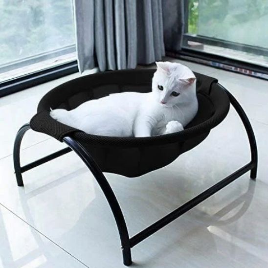 hamac pour chat de couleur noir fait de tissu maillé et sur un support noir avec un beau chat blanc coucher dedans