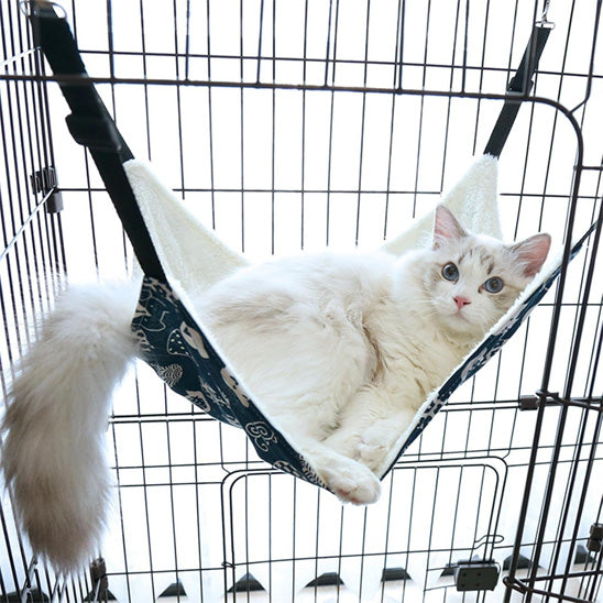 hamac pour chat suspendu dans une cage avec un beau chat coucher dessus confortablement