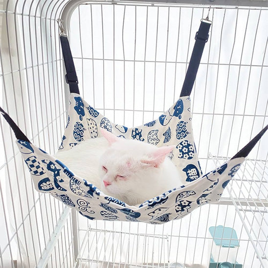 hamac pour chat blanc avec des motifs bleu avec un beau chat blanc coucher dessus