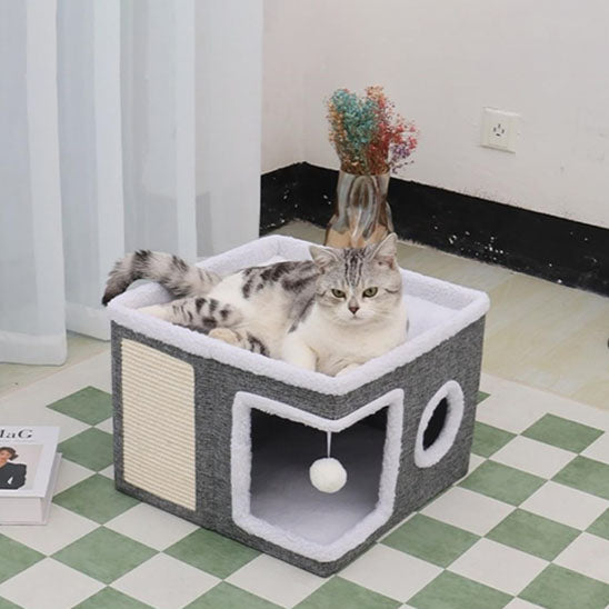 maison pour chat de couleur gris et blanc fait de peluche et coton avec un toit une porte et une balle pour l'amusement