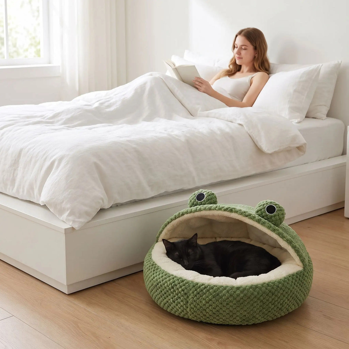niche pour chat en forme de grenouille avec un chat noir qui dort paisiblement dans une chambre à coucher avec une femme qui lit dans son lit