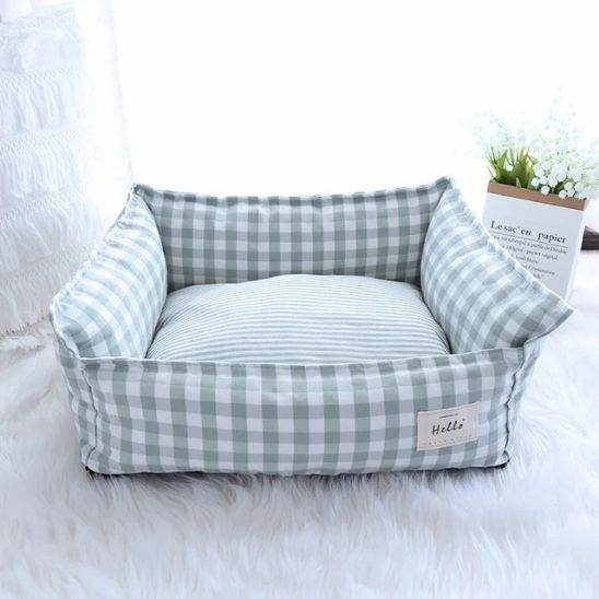 panier pour chat avec carreaux vert et blanc avec forme de sofa dans une pièce lumineuse