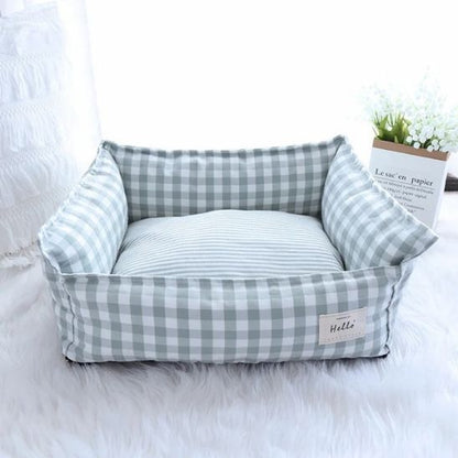 panier pour chat avec carreaux vert et blanc avec forme de sofa dans une pièce lumineuse