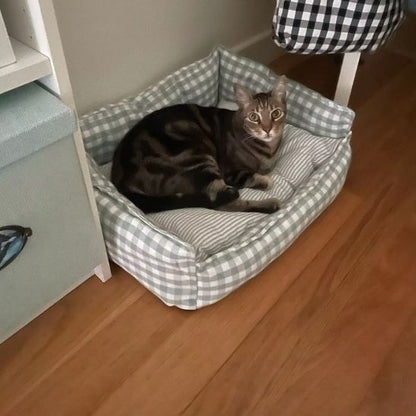 panier pour chat avec un beau grand chat bien installer pour la sieste et le panier est de couleur vert et blanc en carreaux